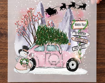 Puede incluir: Una hoja de transferencia DTF con un coche rosa que lleva un árbol de Navidad, un muñeco de nieve y un poste con el texto North Pole, Elf Workshop, Reindeer Barn y Santa's House. Arriba, una silueta del trineo de Santa vuela.