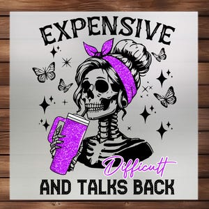 Op de afbeelding: Grafische illustratie van een schedel met een paarse hoofdband en een glinsterende paarse beker. De tekst luidt "EXPENSIVE, Difficult, AND TALKS BACK". Vlinders en sterren zijn ook afgebeeld.