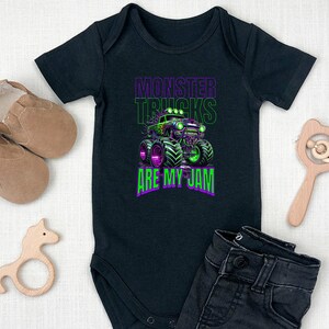 May include: Black baby grow with a green monster truck graphic and the text "Monster Trucks Are My Jam".