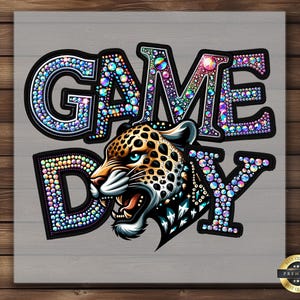 May include: A colorful rhinestone design that says "GAME DAY" with a fierce leopard illustration in the center. The design is on a gray background.