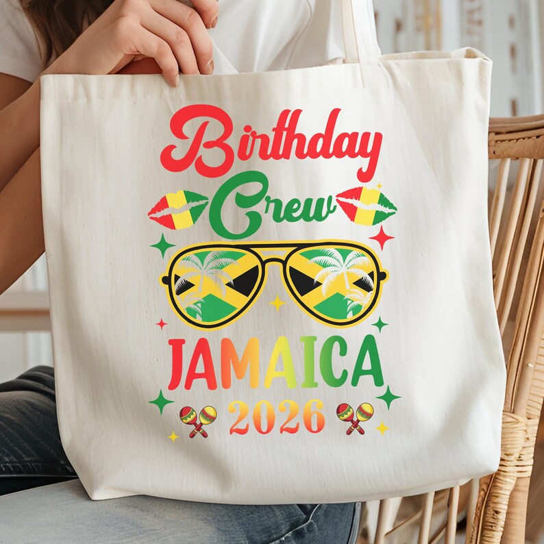 A white tote bag with a colorful graphic design featuring sunglasses, a Jamaican flag, and text that says "Birthday Crew Jamaica 2026".