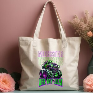 May include: A white canvas tote bag featuring a green monster truck graphic and the text "Monster Trucks Are My Jam" in purple and green.