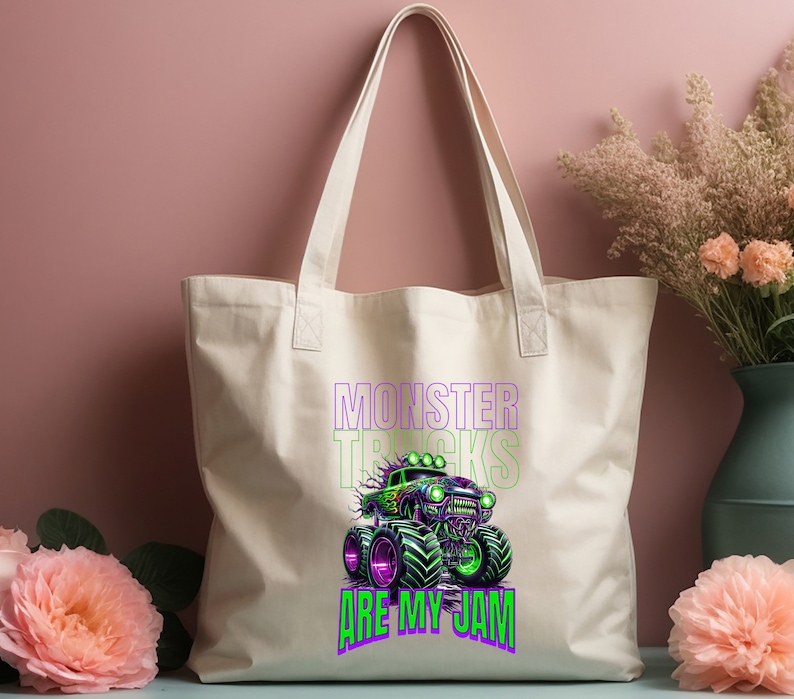 May include: A white canvas tote bag featuring a green monster truck graphic and the text "Monster Trucks Are My Jam" in purple and green.