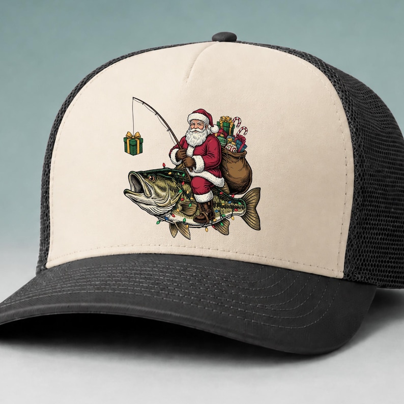 May include: A beige and black trucker hat featuring a graphic of Santa Claus riding a large fish. Santa wears a red suit, carries a brown sack of gifts, and holds a fishing rod with a green gift box on the line. The fish is decorated with colorful lights.
