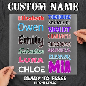 May include: A gray sheet displaying 14 custom name font styles in various colors and typefaces. The text reads CUSTOM NAME at the top and READY TO PRESS 14 FONT STYLES at the bottom, with names including Elizabeth, Owen, Emily, Sebastian, Luna, Chloe, Theodore, Scarlett, Violet, Charlotte, Sophia, Eleanor, and Mia.