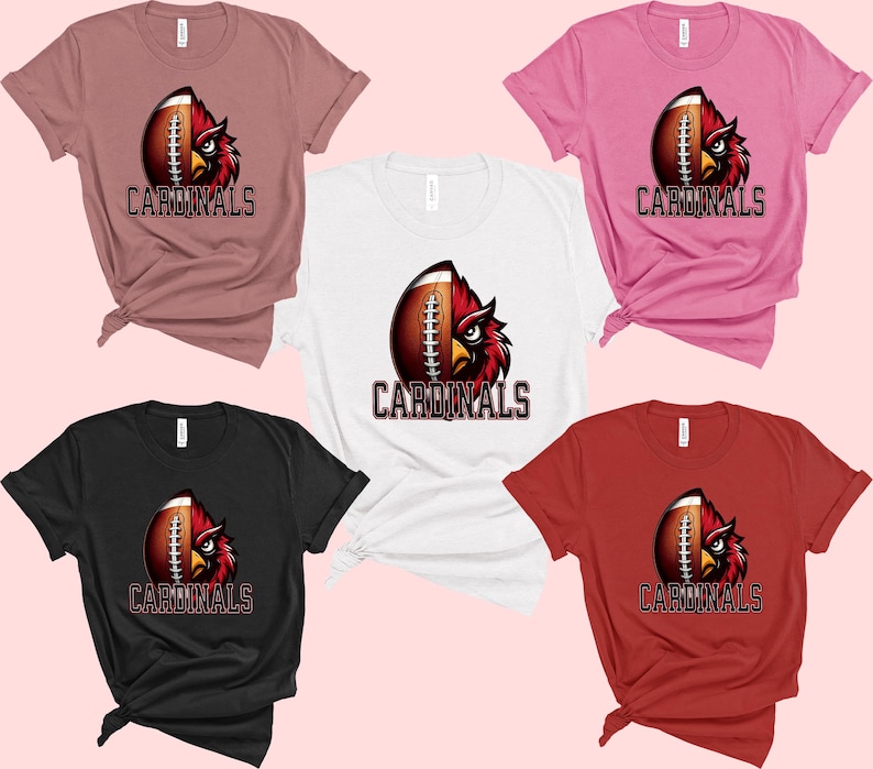Puede incluir: Cinco camisetas de diferentes colores, cada una con un bal&oacute;n de f&uacute;tbol con un gr&aacute;fico de p&aacute;jaro cardenal y la palabra "CARDINALS" impresa en la parte delantera.