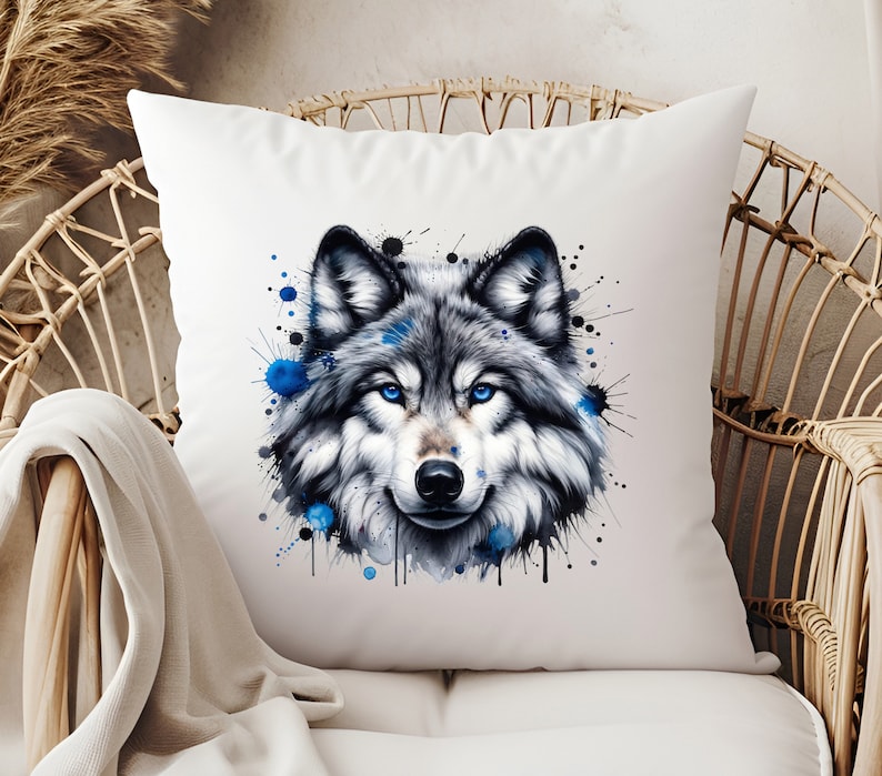 May include: A white throw pillow with a watercolor design of a wolf's face. The wolf has blue eyes and the design is surrounded by blue and black watercolor splatters.