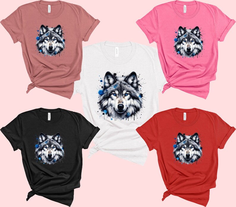 May include: Five t-shirts with different colors, each featuring a watercolor-style wolf with blue accents. The wolf is centered on each shirt.