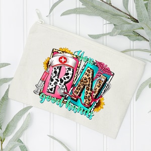 May include: A white canvas zippered pouch with a colorful graphic design featuring the letters "RN" in a leopard print and pink, with a stethoscope, a syringe, a sunflower, and the text "You good hands".
