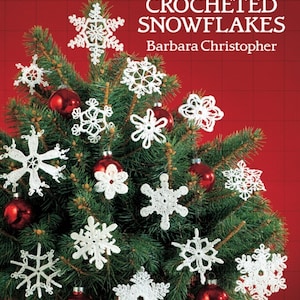 May include: A Christmas tree decorated with crocheted white snowflakes and red ornaments. The book cover in the background reads "60 Crocheted Snowflakes" by Barbara Christopher. The Dover Needlework Series book is set against a red background.