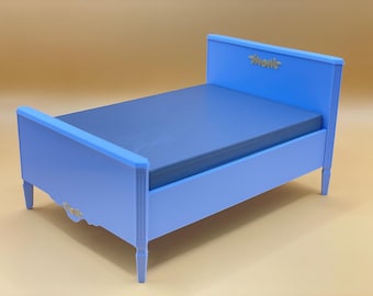 Può includere: Un letto in legno blu chiaro con una testata bianca e un design semplice. La testata ha la scritta "Shonk".