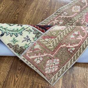 Peut inclure: Un tapis patchwork multicolore avec un motif floral. Le tapis est roulé et a un dos bleu clair.
