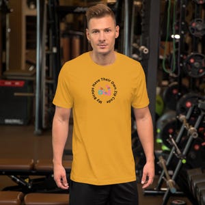 May include: A yellow short-sleeved t-shirt with a black circle graphic that says "My biceps have their own zip code".