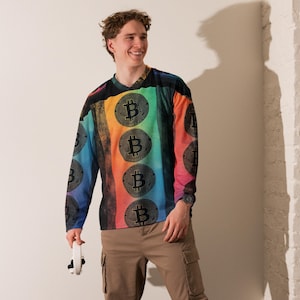 May include: A long-sleeved shirt with a rainbow pattern and black Bitcoin symbols. The shirt has a V-neck and is made of a soft, comfortable material.