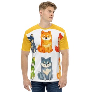 May include: A yellow, white, and blue t-shirt with a colorful illustration of six Shiba Inu dogs. The dogs are all different colors, including red, orange, yellow, green, blue, and purple.