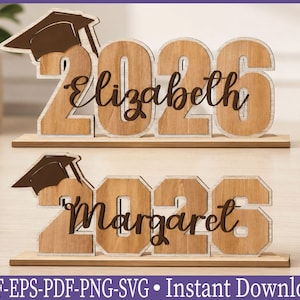 Peut inclure: Décoration de remise de diplôme en bois avec l'année 2026, une coiffe de diplômé et un nom, "Elizabeth" ou "Margaret". Les chiffres et les noms sont de couleur marron clair, posés sur une base en bois.