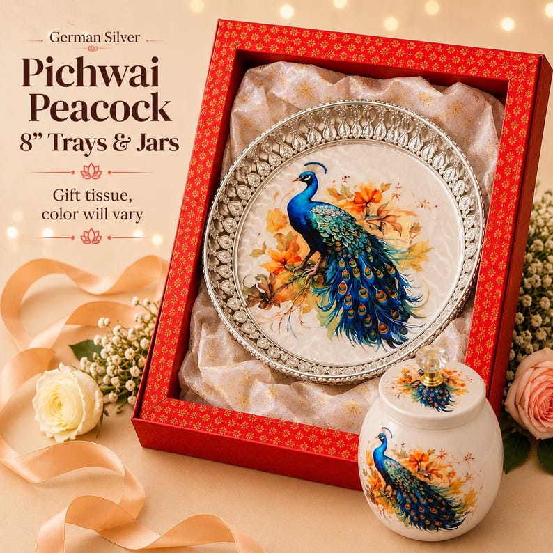 May include: A German Silver 8-inch tray and jar set featuring a peacock design. The tray has a decorative silver border and a central peacock illustration. The matching jar has a lid with a clear knob. Both items are presented in a red box.