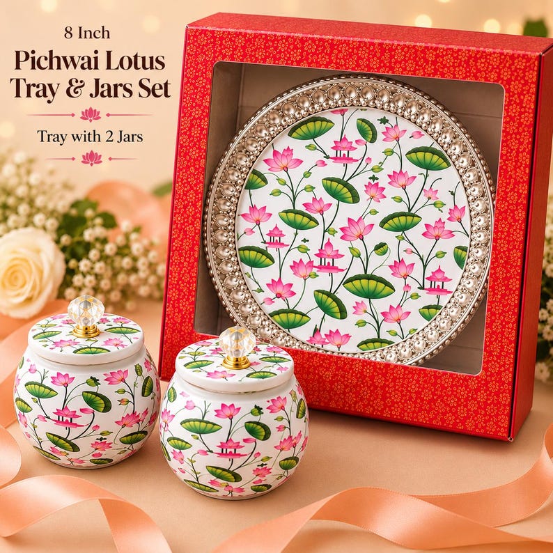 May include: An 8-inch Pichwai Lotus tray and two jars set featuring a white surface with a repeating pink lotus flower and green leaf pattern. The round tray has a metallic beaded rim, and both jars include matching lids with clear crystal knobs.