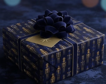 May include: A square gift box wrapped in dark blue paper featuring a repeating gold and blue nutcracker pattern. The package is tied with a dark blue velvet ribbon bow and includes a small gold square gift tag with a star icon.