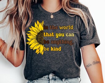 May include: A dark grey t-shirt with a sunflower graphic and the text "In the world that you can be anything, be kind".