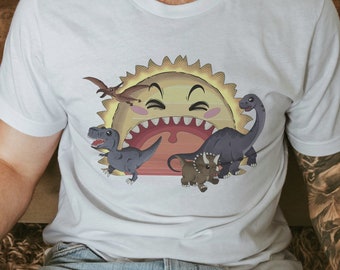 May include: White t-shirt featuring a cartoon sun with a smiling face and a row of teeth. The sun is surrounded by a Pterodactyl and several dinosaurs in shades of gray and brown. The shirt is a crew neck.