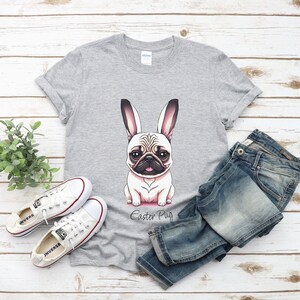 May include: A grey t-shirt featuring a cartoon pug wearing bunny ears. The text "Easter Pug" is printed below the image.
