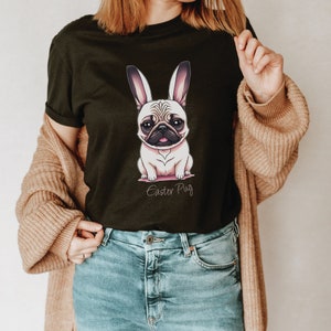 May include: A black t-shirt featuring a cartoon pug wearing bunny ears. The text "Easter Pug" is printed below the image.