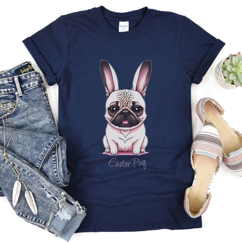 May include: A navy blue t-shirt featuring a cartoon pug wearing bunny ears. The text "Easter Pug" is printed below the image.