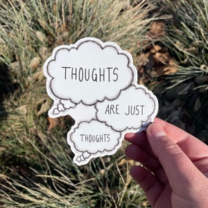 Pu&ograve; includere: Un adesivo bianco con tre bolle di pensiero. La bolla in alto dice "THOUGHTS", la bolla al centro dice "ARE JUST" e la bolla in basso dice "THOUGHTS".