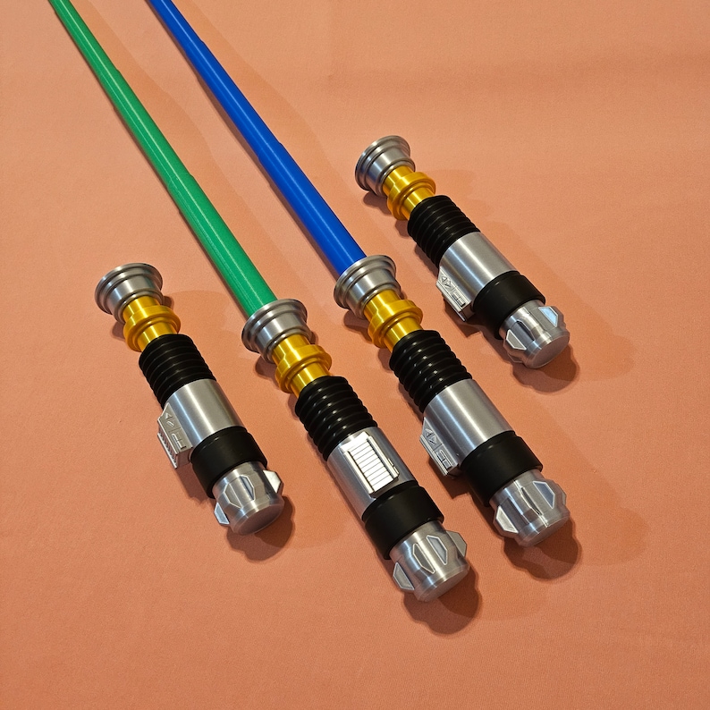 May include: Four lightsaber toys with silver and gold handles and green, blue, and silver blades.