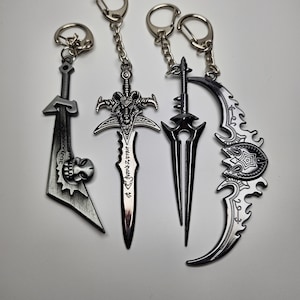 Puede incluir: Cuatro llaveros plateados con diferentes diseños de espadas. Las espadas están detalladas con diseños intrincados y tienen acentos negros.