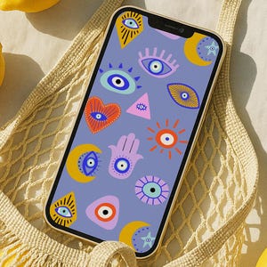 May include: A smartphone with a gold frame displays a pattern of colorful eye and hand illustrations on a lavender background. A beige net bag holds lemons, with additional lemons scattered around the phone. The scene is set on a light-colored surface.