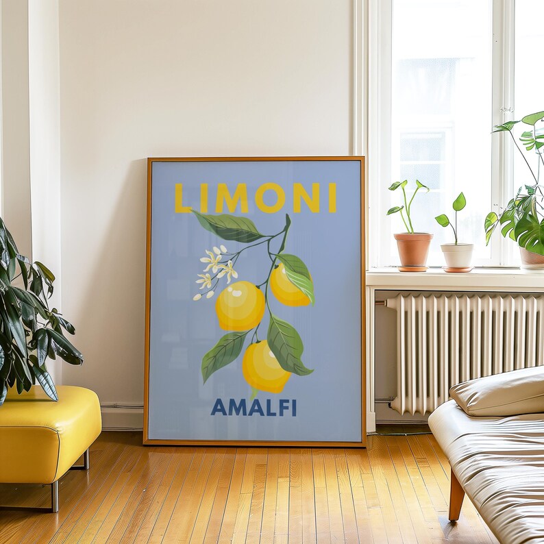 May include: A framed art print featuring a lemon branch with yellow lemons, green leaves, and white blossoms against a light blue background. The word "LIMONI" is in yellow above "AMALFI" in blue.