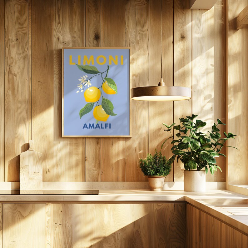 May include: A framed art print featuring a lemon branch with yellow lemons, green leaves, and white blossoms against a light blue background. The word "LIMONI" is at the top, and "AMALFI" is at the bottom.
