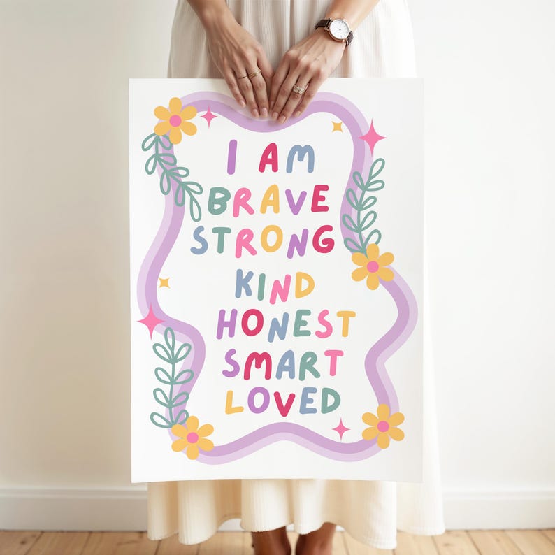May include: A white poster with the words "I AM BRAVE STRONG KIND HONEST SMART LOVED" in colorful letters. The words are framed by a wavy purple border, flowers, and leaves.