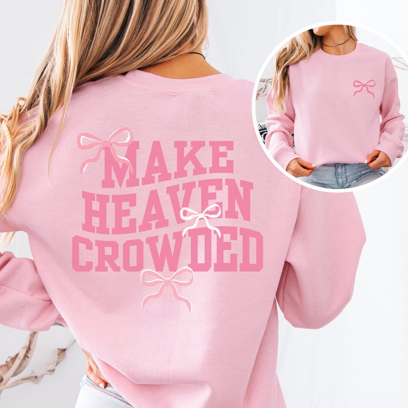 May include: Pink sweatshirt with the text "MAKE HEAVEN CROWDED" in white lettering and pink bows on the back. The front of the sweatshirt has a single pink bow on the left side.