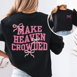 May include: Black sweatshirt with pink text that reads "Make Heaven Crowded" and pink bows.