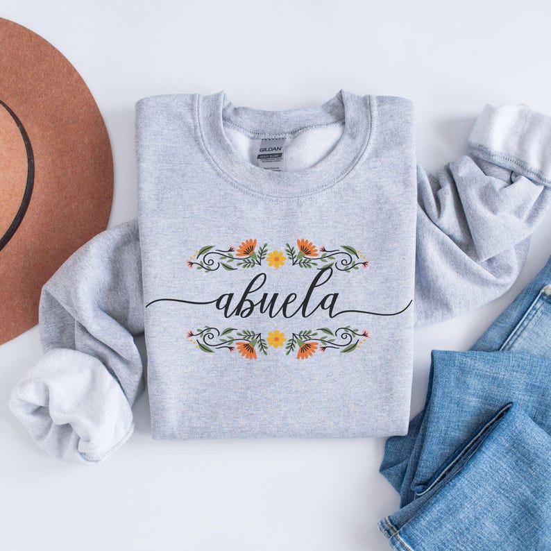 May include: A gray sweatshirt with a floral design and the word "abuela" in black script.