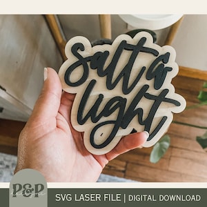 May include: A wooden sign with the words "Salt & Light" written in black script font.