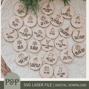 Könnte beinhalten: Ein Set mit 25 Holz-Weihnachts-Countdown-Kreisen mit verschiedenen festlichen Aktivitäten und Sätzen, wie "Backen Sie Kekse", "Sehen Sie sich einen Weihnachtsfilm an" und "Machen Sie einen Winterspaziergang".