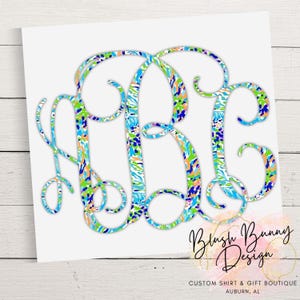 May include: A monogram design featuring the letters ABJ in a colorful pattern of blue, green, orange, and white. The design is on a white background with the text "Blush Bunny Design" and "CUSTOM SHIRT & GIFT BOUTIQUE AUBURN, AL".