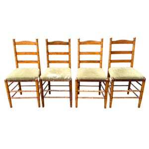 May include: A white ceramic mug with a black handle and the text "But First, Coffee" in a bold, black font. The mug is set against a blurred background, suggesting a cozy setting.