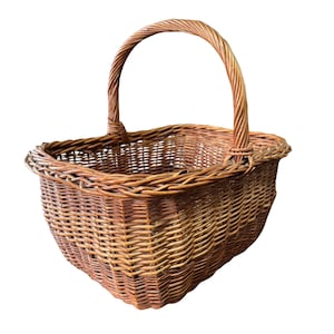 May include: A brown wicker basket with a curved handle. The basket is woven with a tight pattern and has a rounded shape. The handle is also made of woven wicker and is attached to the basket's sides.