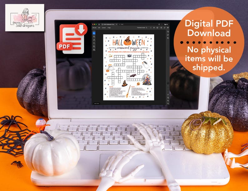 May include: A digital download of a Halloween crossword puzzle displayed on a laptop screen. The screen shows a crossword puzzle featuring a pumpkin, a witch's hat, a bat, and a cauldron. The laptop is surrounded by Halloween decorations, including pumpkins, a spider web, and a skeleton hand.