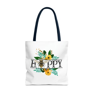 May include: White tote bag with a navy blue handle. The bag features a floral design with a bee in the center and the word "HAPPY" written in a vintage font.