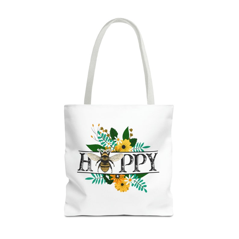 May include: White tote bag with a bee and floral design. The text "HAPPY" is written in a vintage font with the bee in the center of the word.