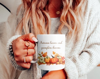 May include: White ceramic mug with a fall-themed design. The mug features a quote that reads "Autumn leaves and pumpkin dreams" with a graphic of pumpkins and fall leaves.