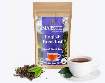 May include: A brown paper bag with a blue and white label that says "MAJESTIC Luxurious Tea English Breakfast Decaf Black Tea Fine Tea, Finer Taste". The bag is filled with tea leaves. There is a cup of tea and a saucer with a green leaf on it.