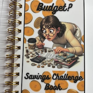 May include: A spiral-bound notebook with a cover featuring an illustration of a person examining finances. The cover text reads "Is it in the Budget?" and "Savings Challenge Book." Gold-colored coins and a coffee cup are also depicted.