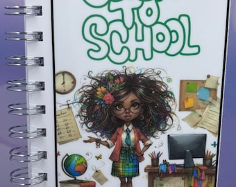 May include: A spiral-bound notebook with a colourful illustration. The cover displays the text "Back to School" in green, a cartoon teacher, and the words "Savings Challenge Book". The notebook has a silver spiral binding.
